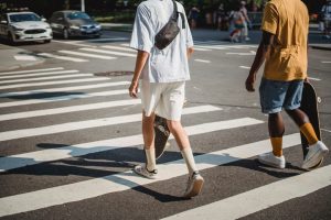 skateboarders crossing a pedestrian crosswalk