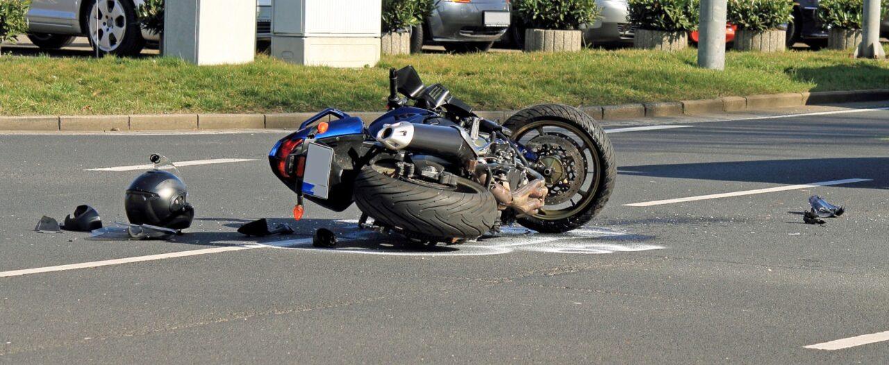 Motorcycle lying on its side in the roadway after a traffic accident with debris scattered nearby