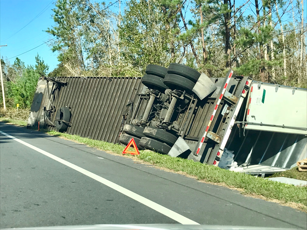 A semi truck tipped over on the side of a Florida highway