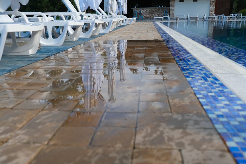 Wet floor next to pool causing a potential slipping hazard